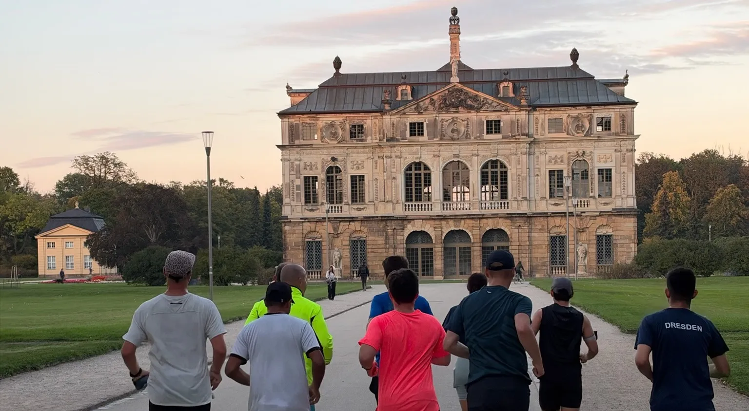 Gruppe von Läuferinnen und Läufern von hinten auf dem Weg zum Palais im Großen Garten